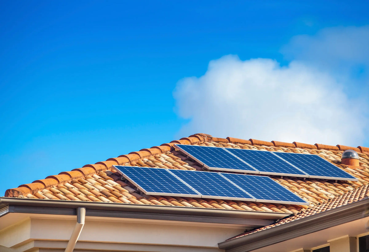 Teilansicht eines Hausdachs mit wenigen installierten Solarmodulen (Photovoltaik-Anlage) zur Stromerzeugung.