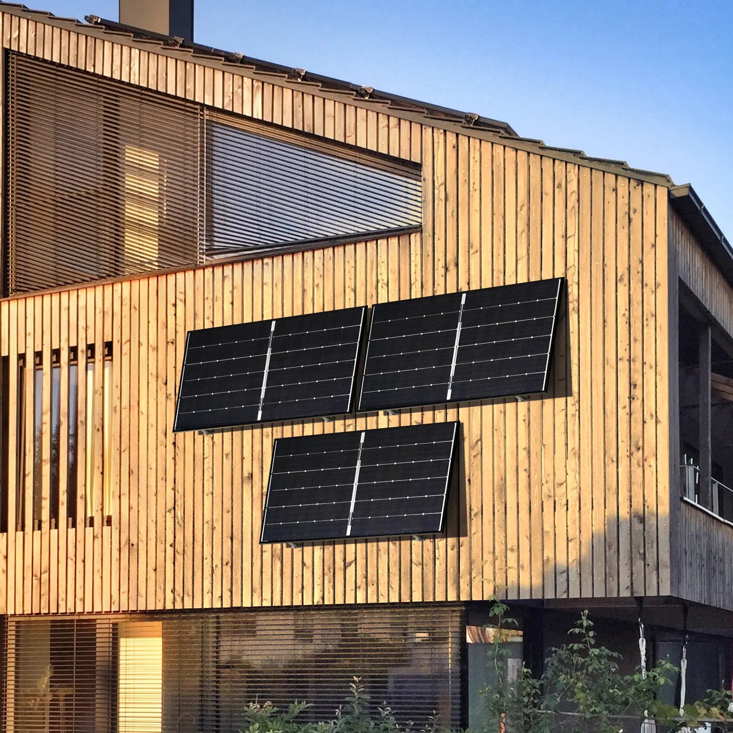 Balkonstrom Balkonkraftwerk Basic Wall 1350 bifazial drei Solarmodule montiert an Holzfassade