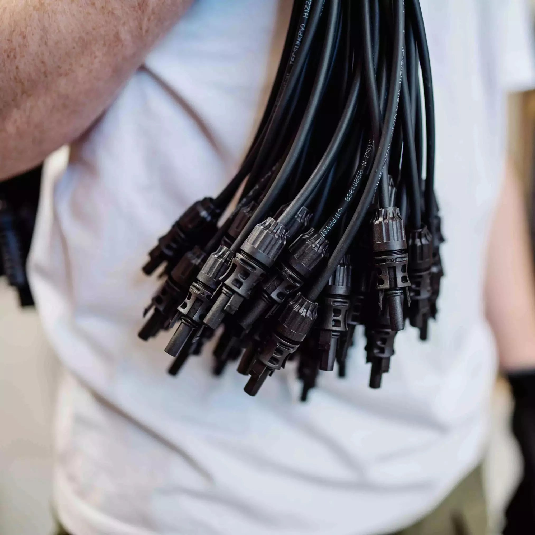 Mann hält viele MC-4 Verlängerungskabel