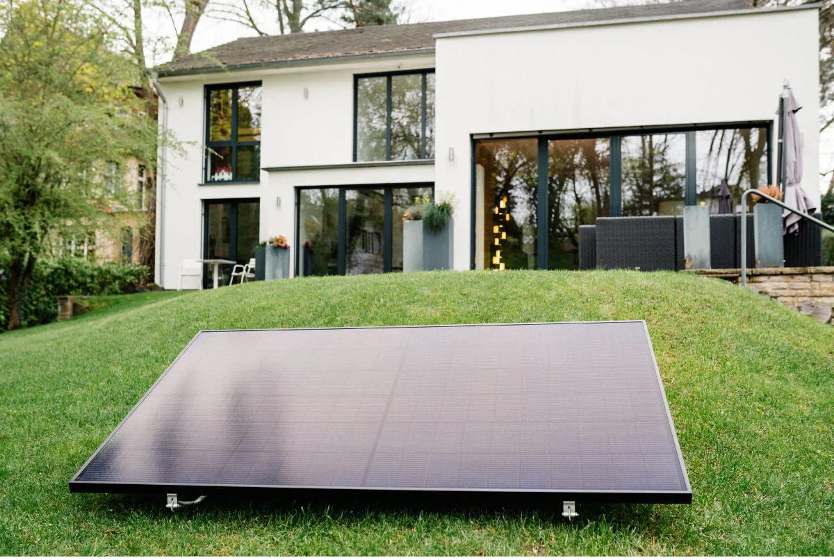 Solarmodul auf dem Rasen vor einem Haus