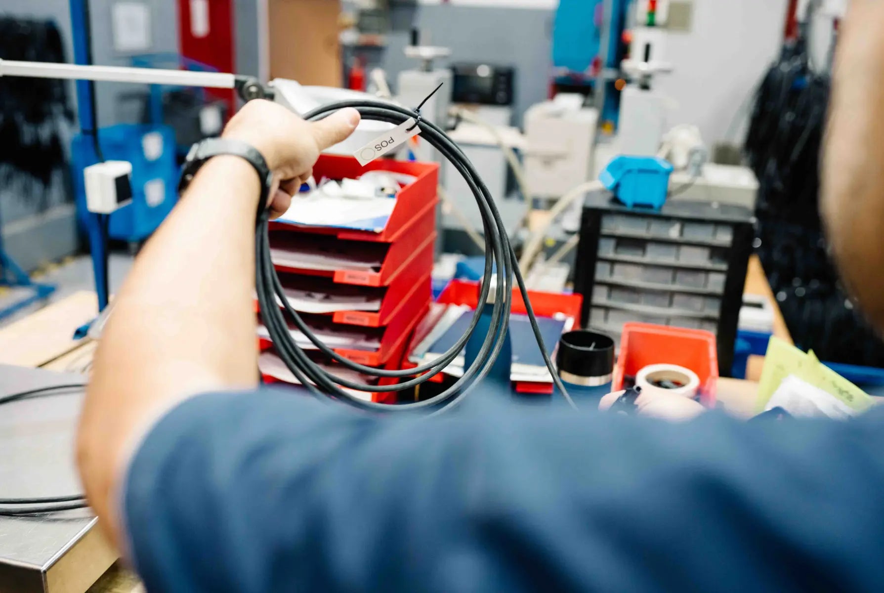 Person hält ein MC-4-Kabel Made in Germany von Balkonstrom in die Luft