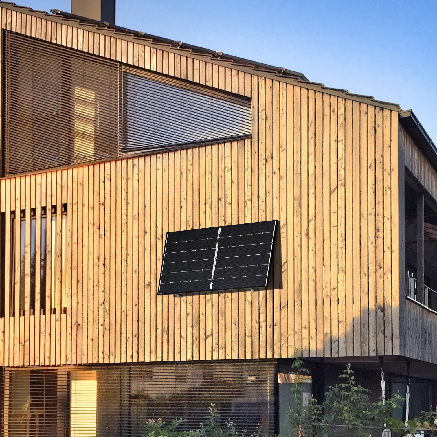 Balkonstrom Balkonkraftwerk Basic Wall 450 bifazial ein Solarmodul montiert an Holzfassade