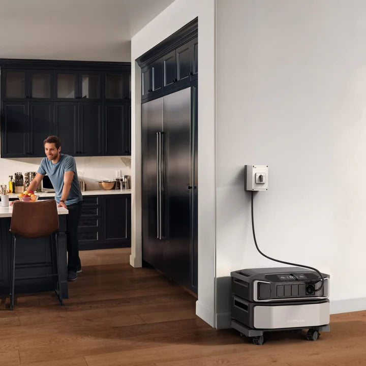 EcoFlow DELTA Pro Ultra im Einsatz, angeschlossen an einer Steckdose, mit Küche und Mann im Hintergrund